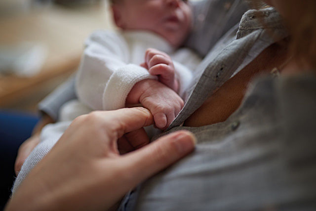 bebé sostenido la mano de su mamá con su manita
