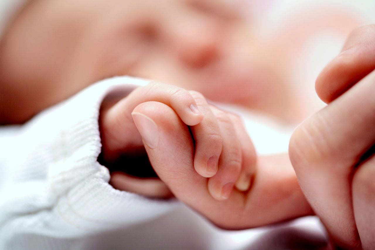 baby holding parents finger