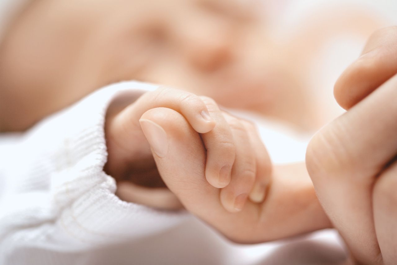 Baby hält Finger vom Elternteil