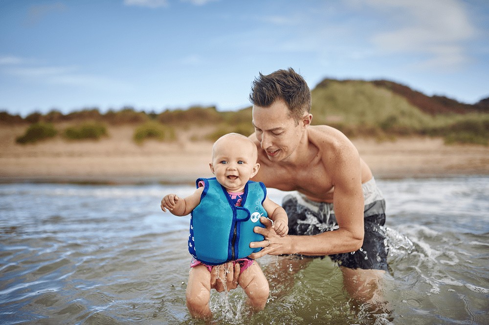 baby op het strand met papa