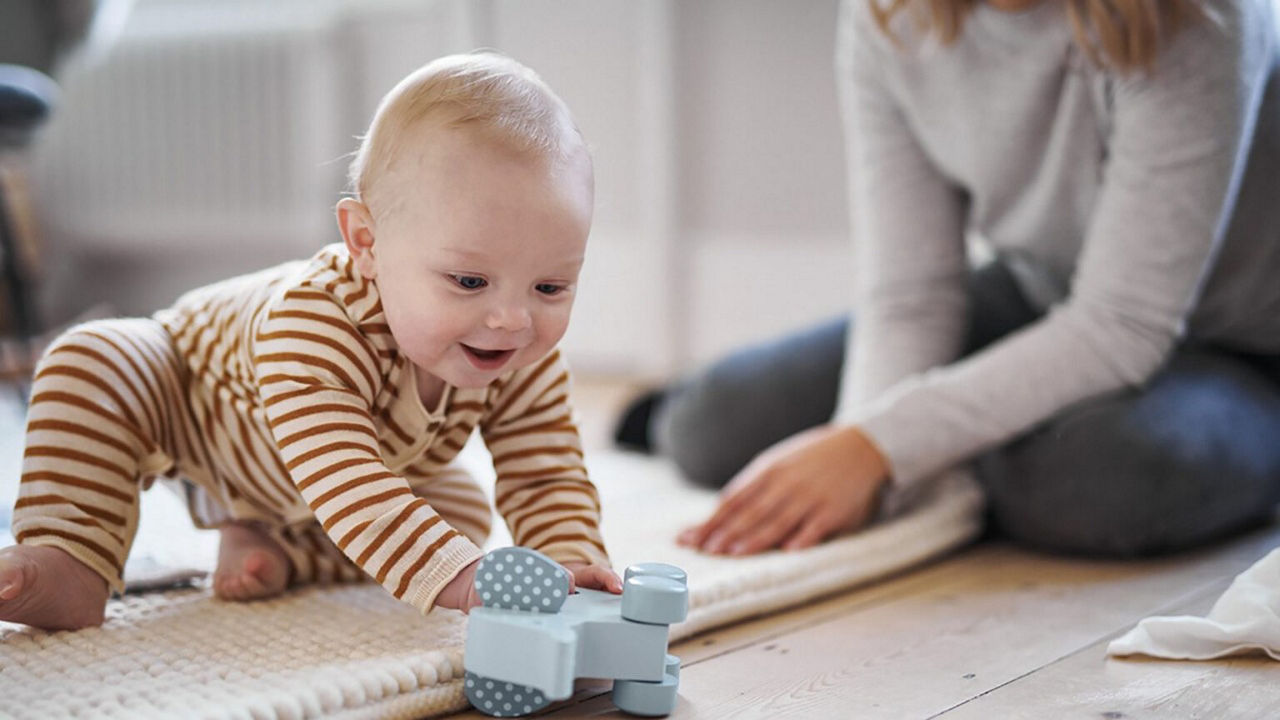 baby playing with wooden elephant