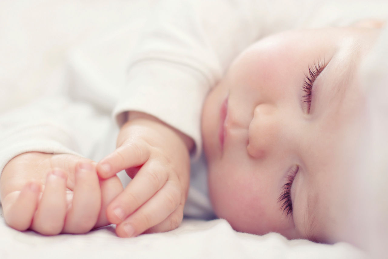 close-up portrait of a beautiful sleeping baby on white