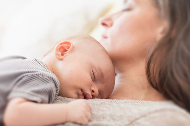 baby sleeping on mothers chest