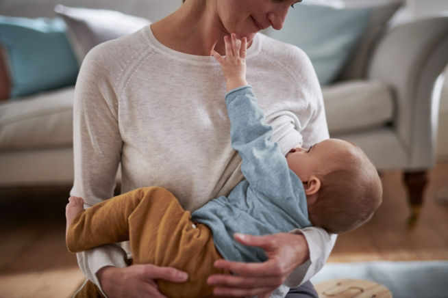 baby touching mother during breastfeeding 2