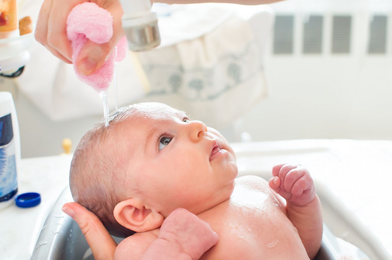 Mae dando banho no bebe recem nascido