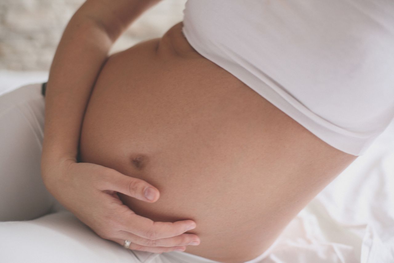 Beautiful pregnant woman lying in her bed.