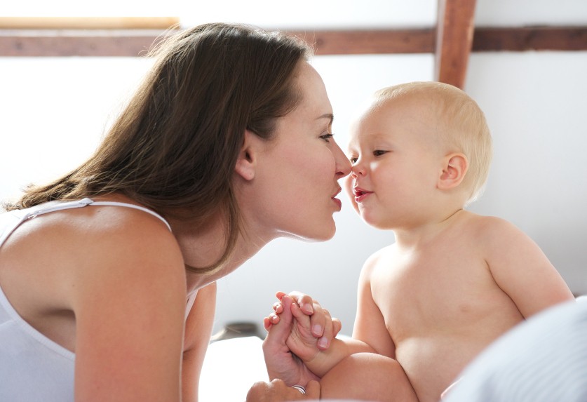 Portrait of a beautiful woman and baby playing on bed,Mum playing with baby on bed