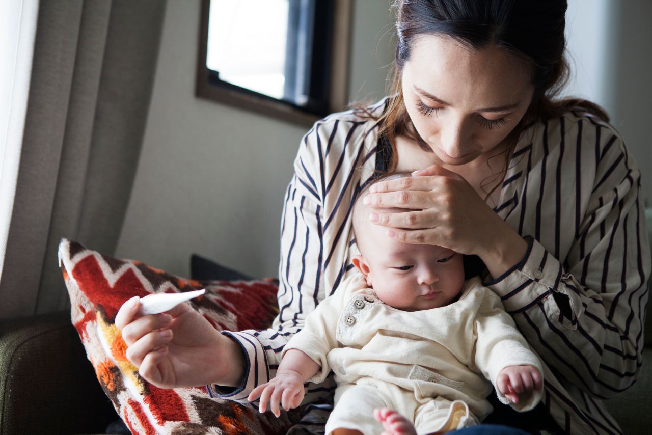 Mae medindo a temperatura do bebe