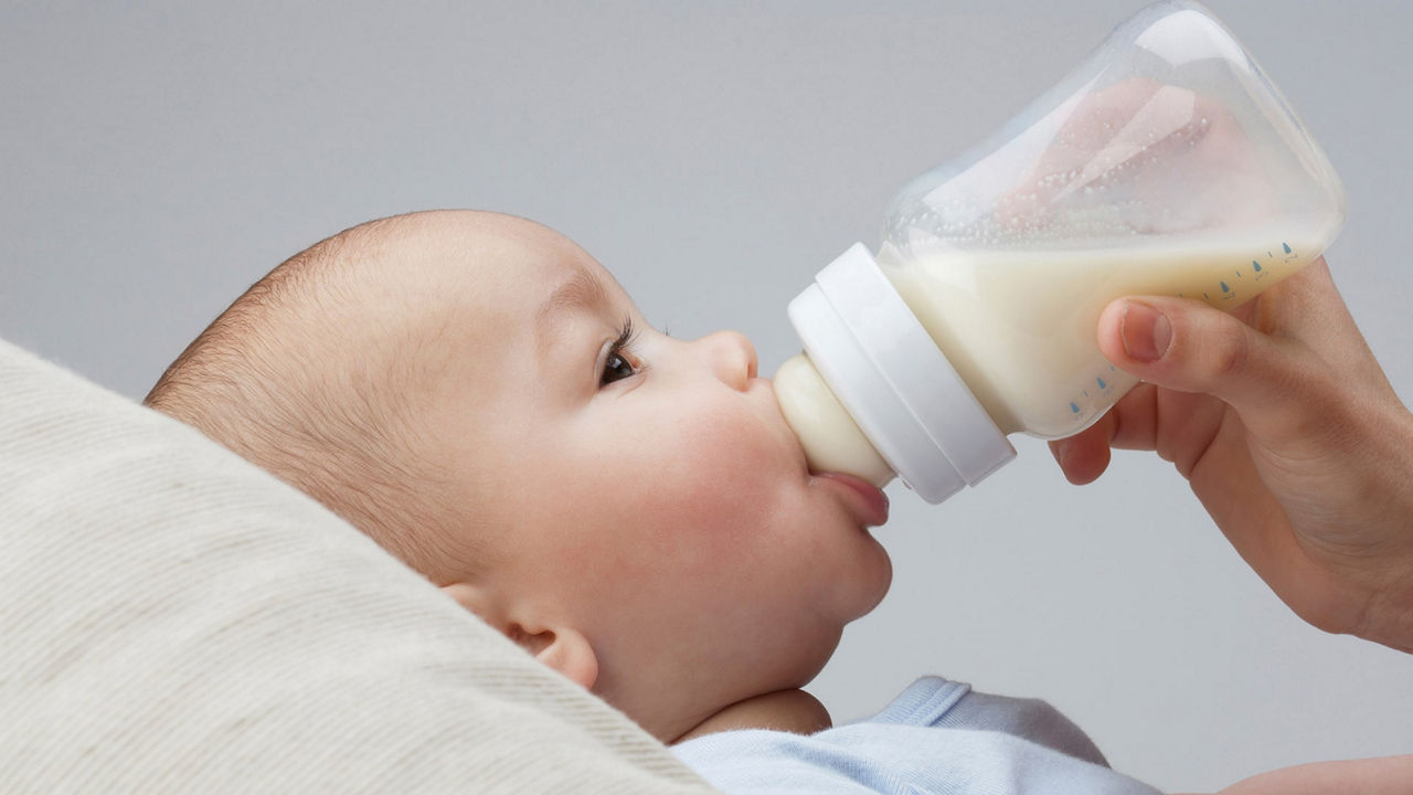 Bebé bebiendo leche de un biberón