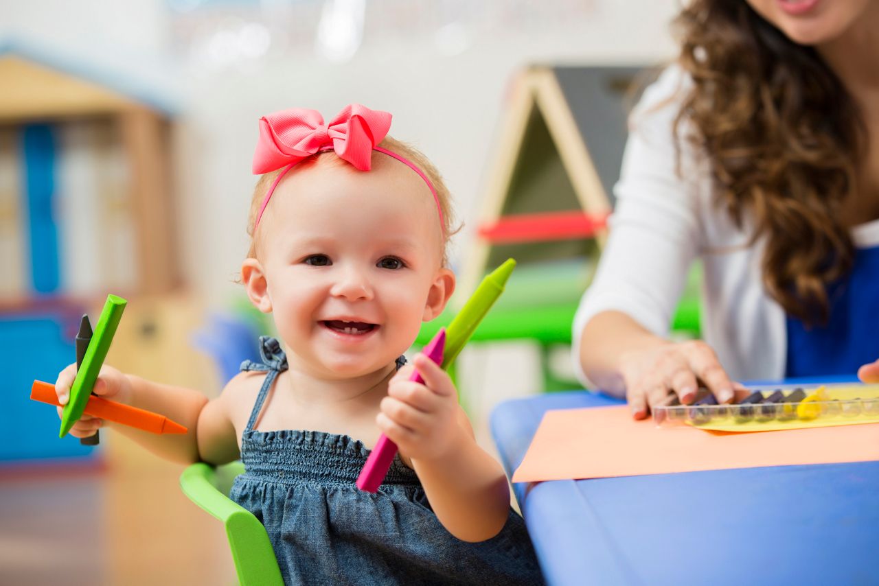 Bebe brinca com giz de cera na creche