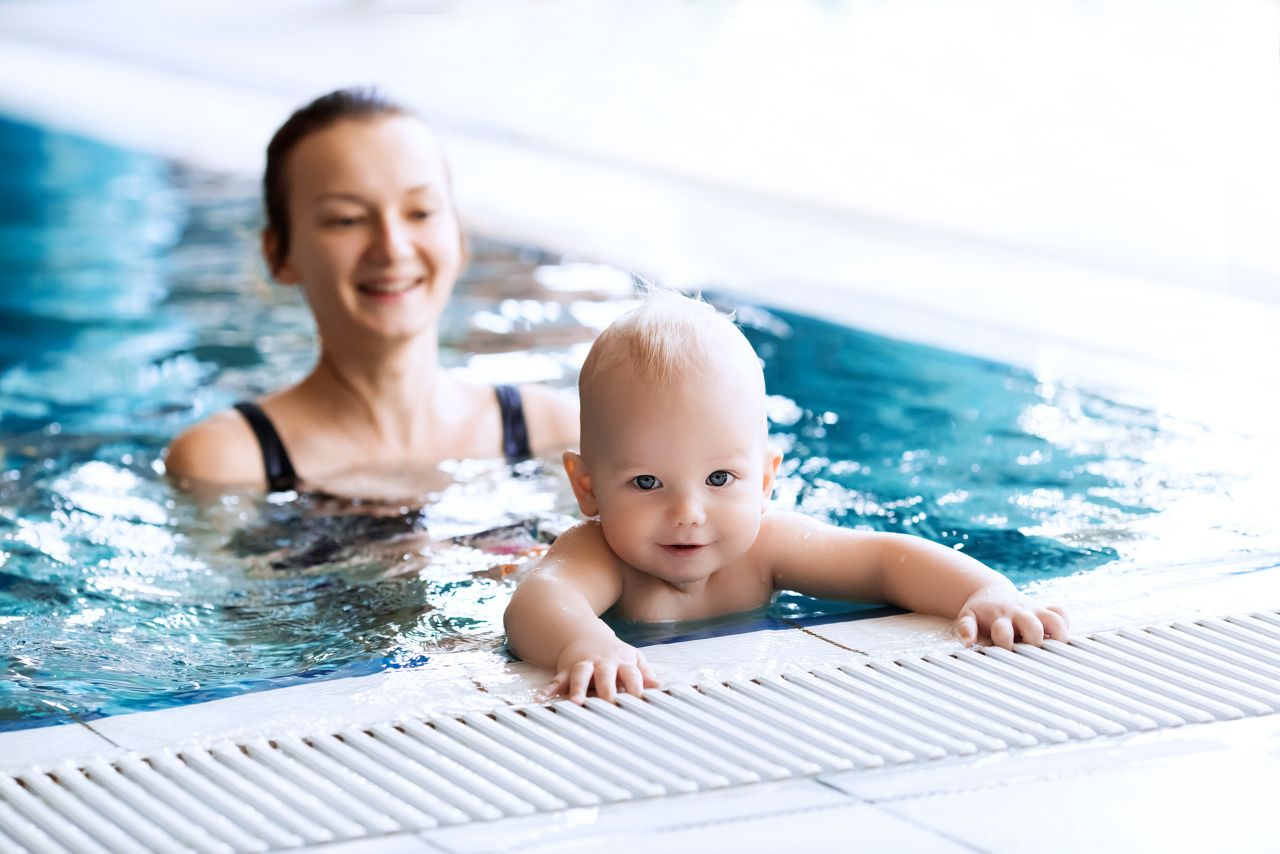 Bebe com sua mae na piscina