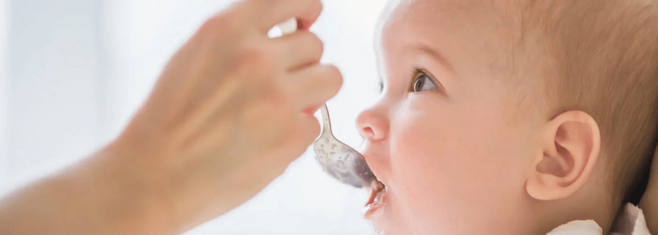 Baby mit Allergie bekommt Beikost gefüttert