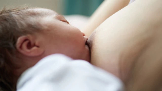 Breastfeeding baby on bed