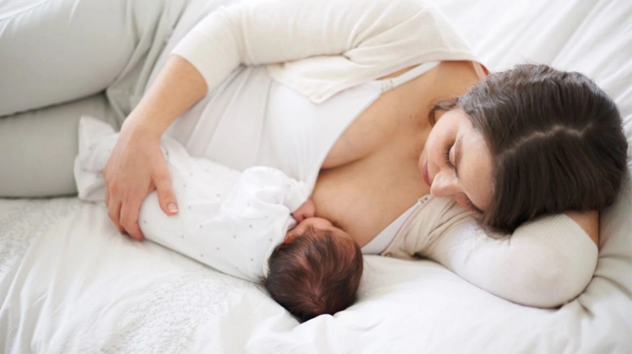 Breastfeeding baby on bed