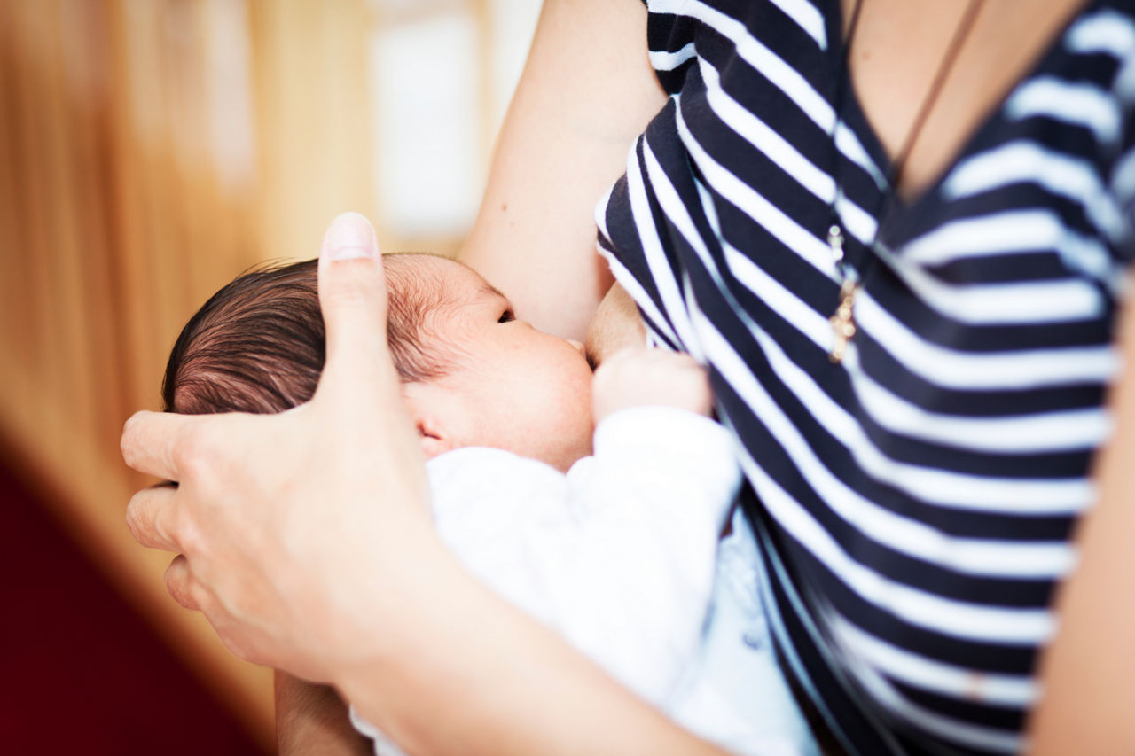 Woman in stripy top breastfeeding child