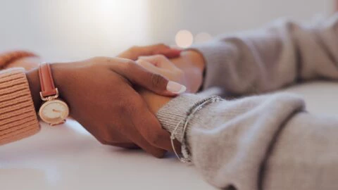 Home, holding hands and women with comfort, support and compassion in living room. Closeup, people and friends with grief, loss and sad with love, unity and trust with empathy, sympathy and help