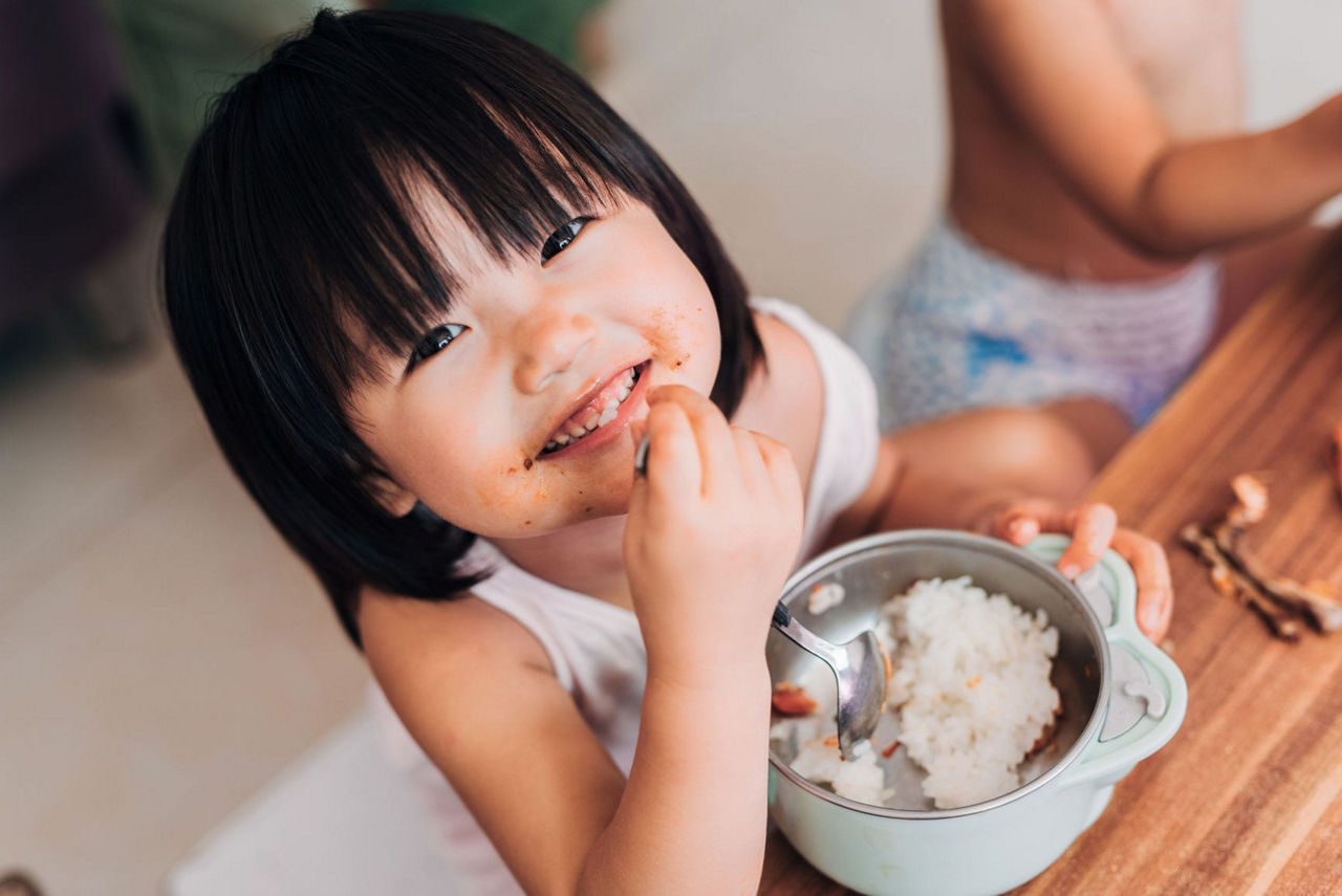 Girl smiing and eating rice