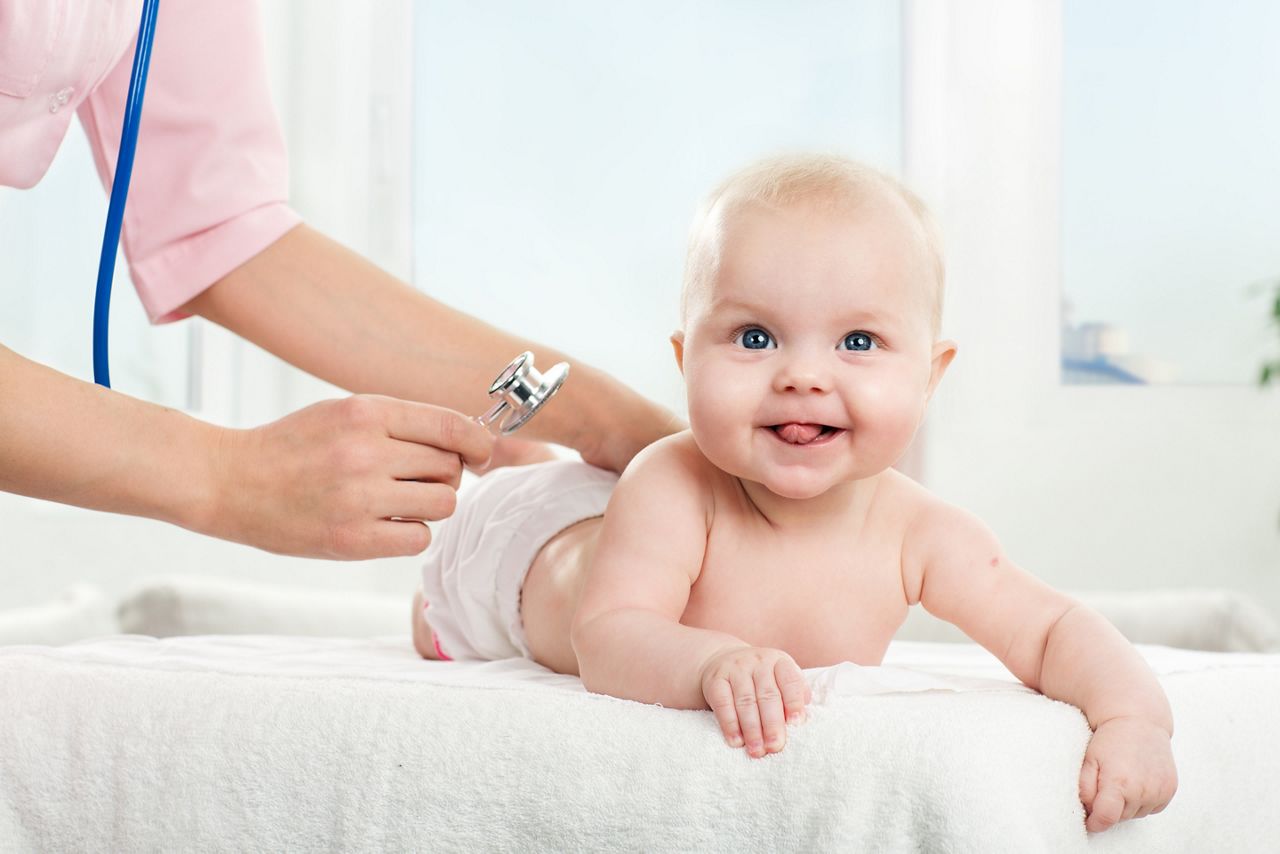 Pediatric doctor exams little baby girl with stethoscope