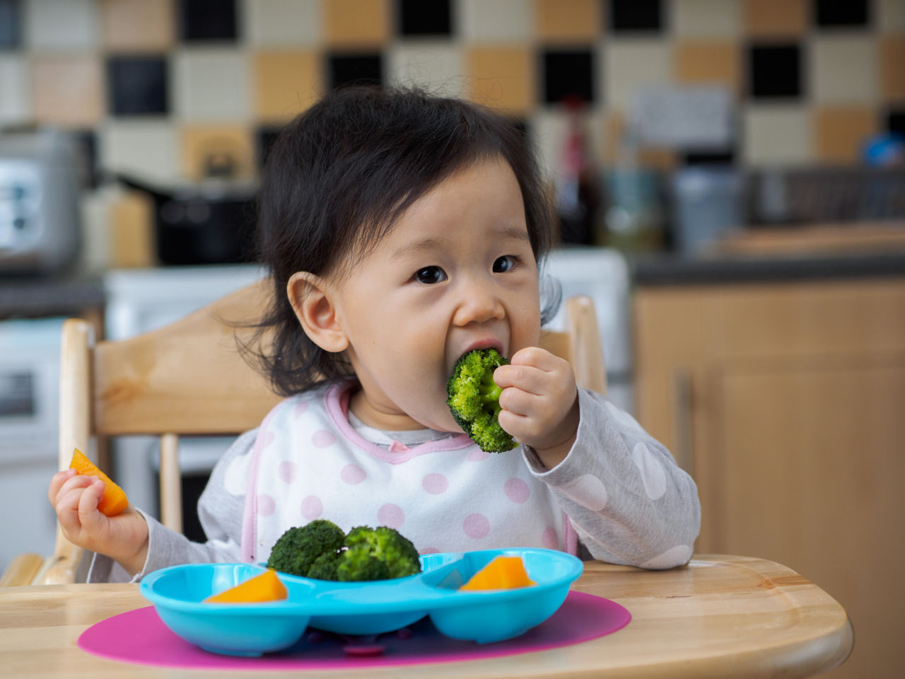 Asian baby girl eating vegetable at home kitchen; Shutterstock ID 611210294; Purchase Order: AptaAdvantage