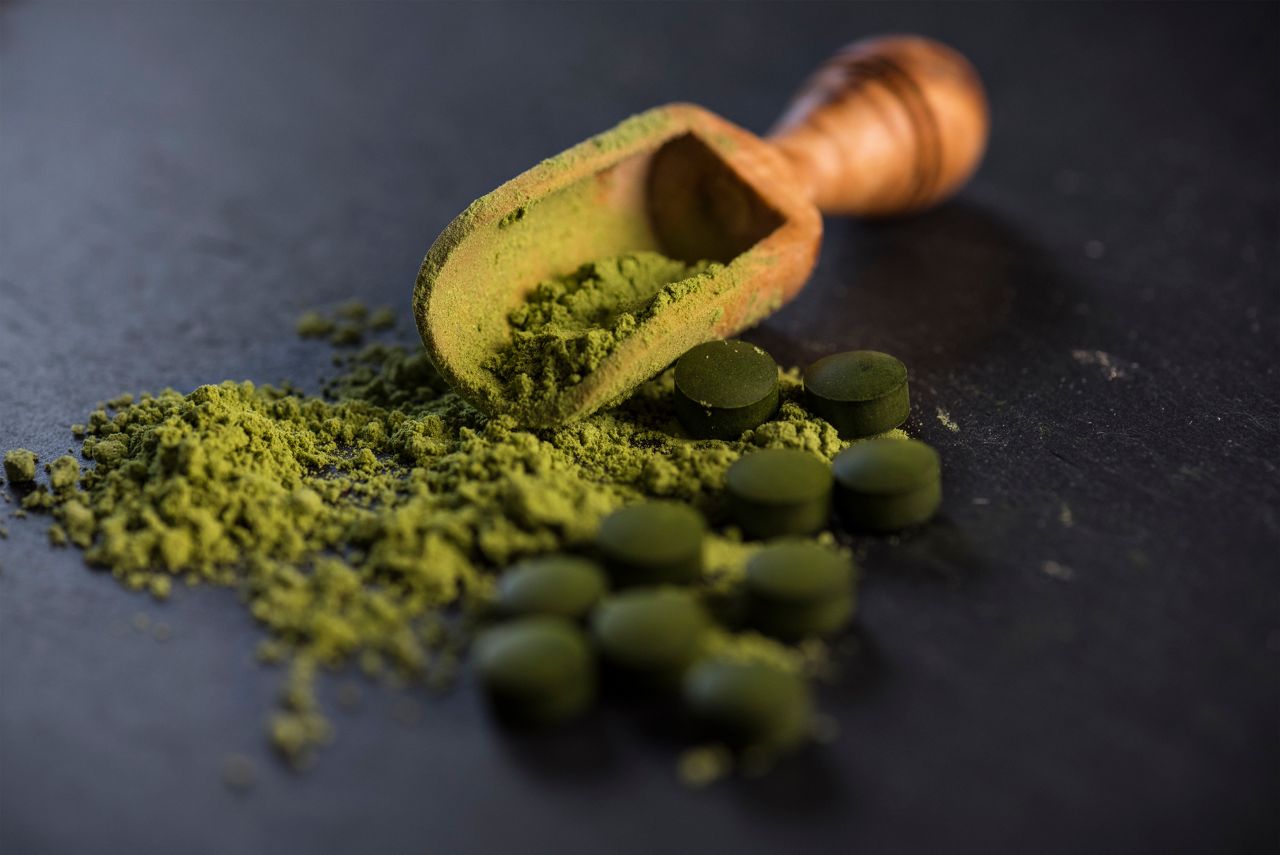 Organic spirulina powder and tablets shot on a slate 