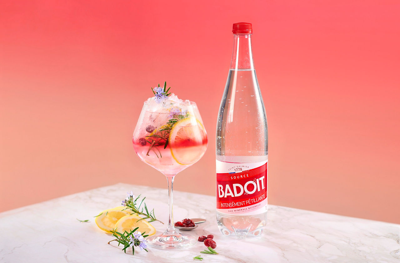 Cocktail sans alcool Badoit sur une table avec des cranberries et du citron