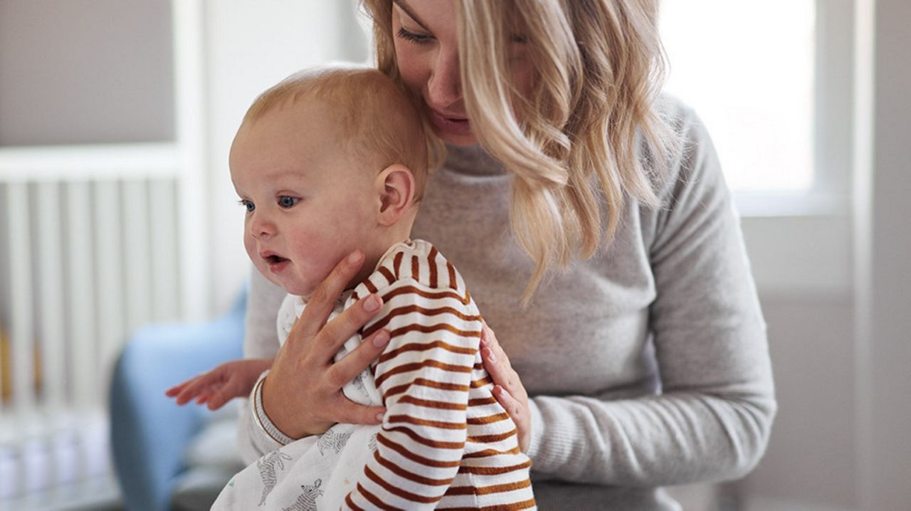 Mother holding a baby in a burping position