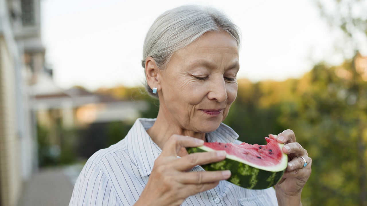 Senior woman enjoying a slice of watermenlon