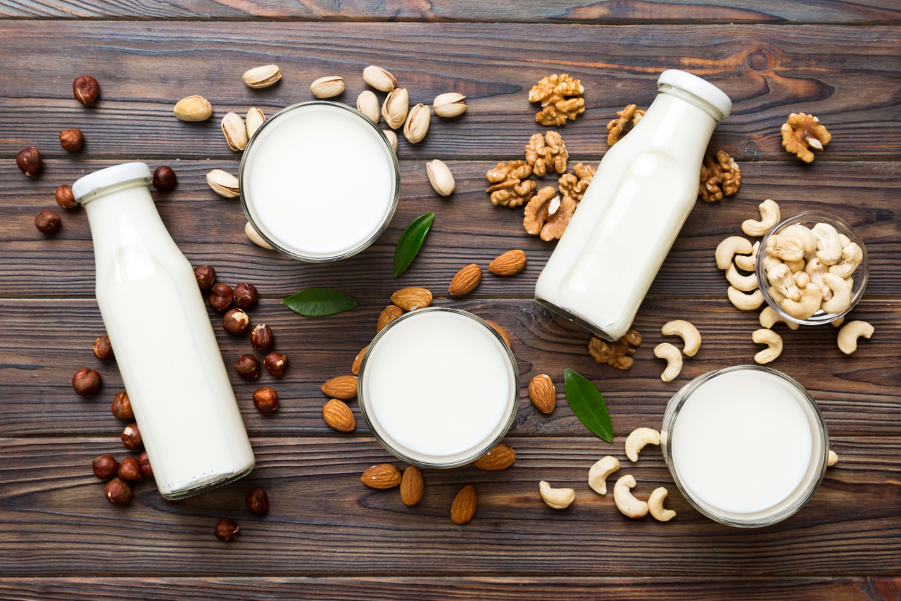 Set or collection of various vegan milk almond, cashew, on table background. Vegan plant based milk and ingredients, top view.; Shutterstock ID 2300431591; purchase_order: Achat articles alpro 2026; job: ; client: ; other: 