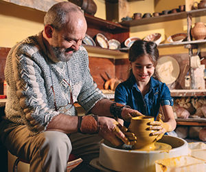 Grandfather and granddaughter doing pottery 