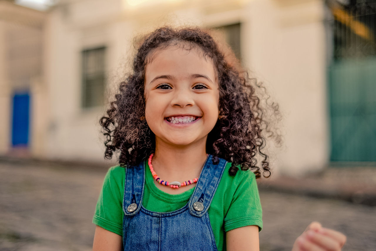 Small girl smiling on the street. looking at the camera