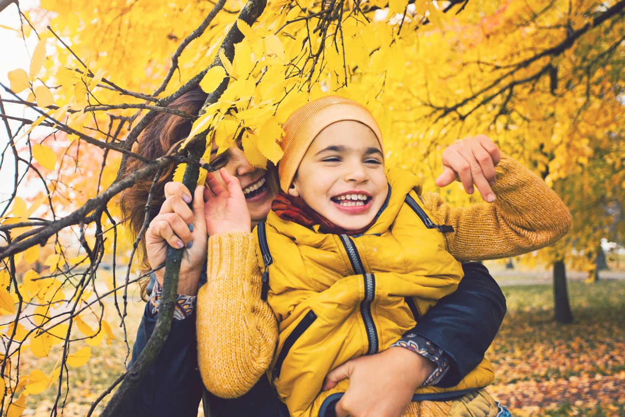 Smiling little boy, kid with disabilities and his mother. Child has cerebral palsy