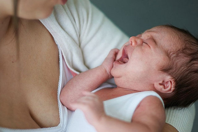 crying newborn in mums arms