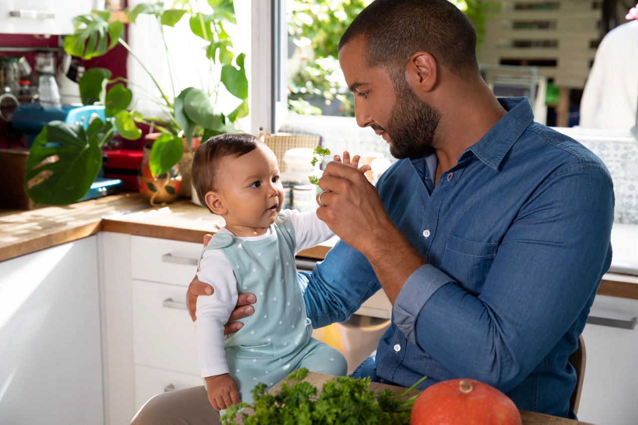 Dad holding son in kitchen