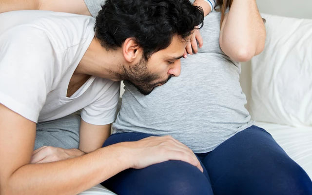 Pregnant women react to their partner supporting their belly 