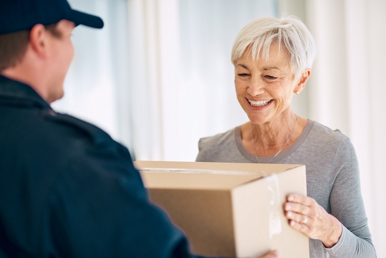 Frau nimmt Paket von Courier entgegen