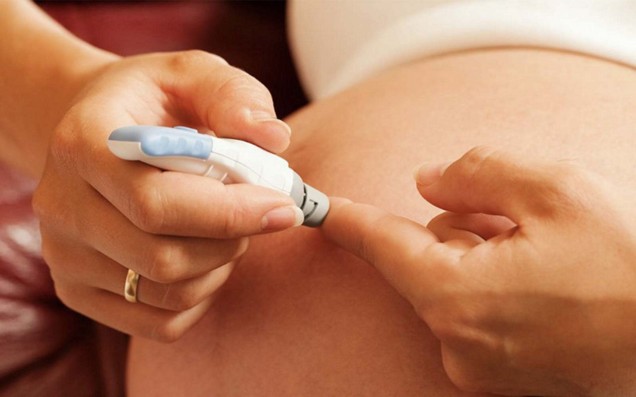 Pregnant woman checking her blood sugar level