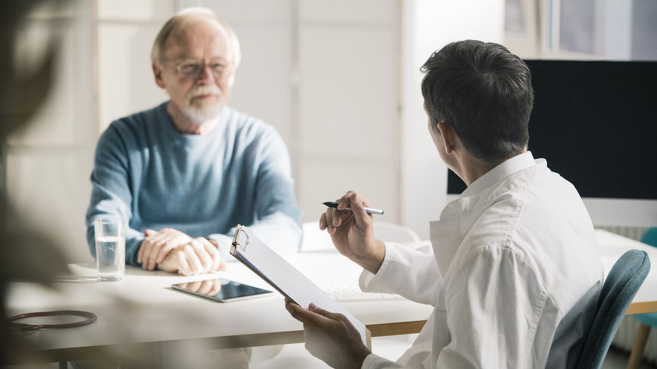 Consultation . GP with clipboard and a male patient