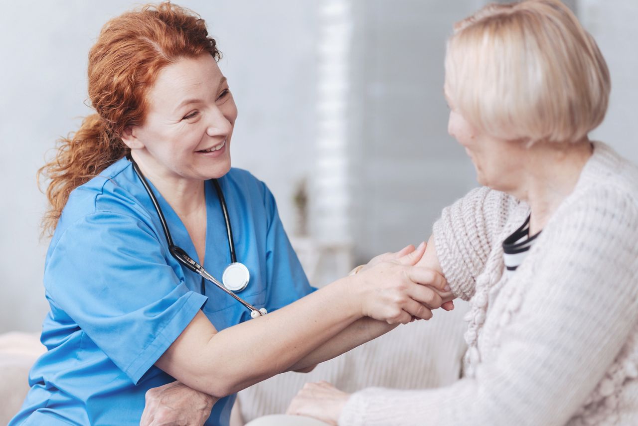 Everything will be good. Selective focus on a radiant doctor smiling while trying to put her retired female patient in a cheerful frame of mind during a regular visit at home.