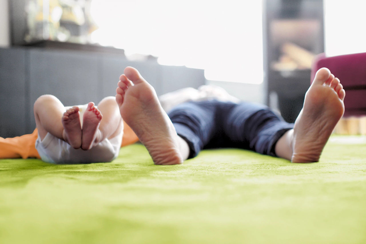 baby and dad laying on the floor