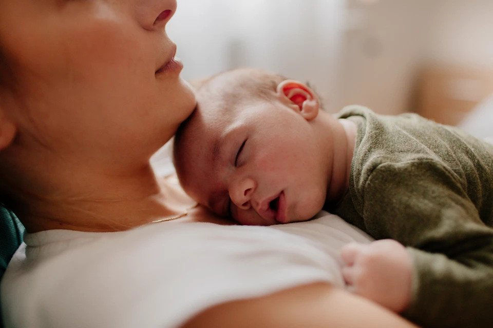 Baby sleeping on mum