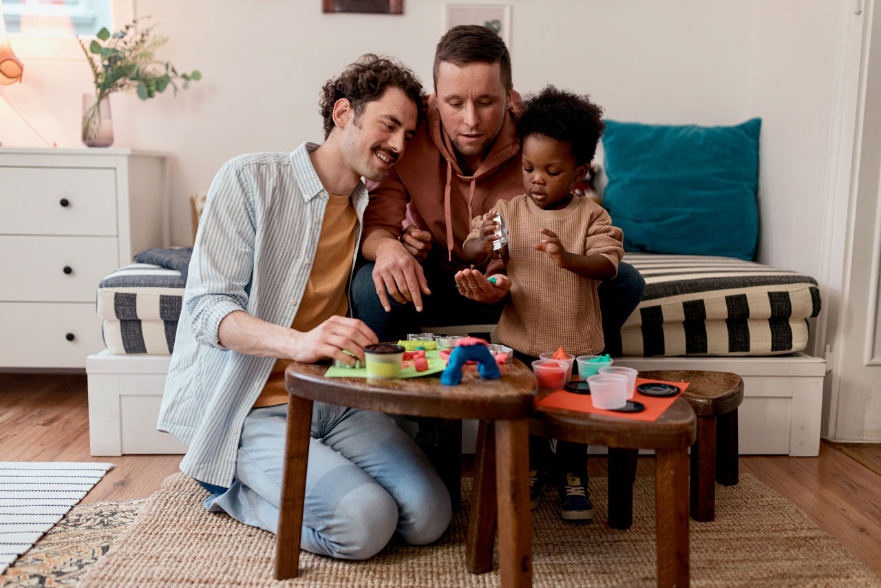 Modern gay couple being creative with their son at home