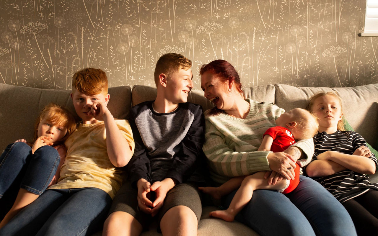 a mother and her five children sittin on the couch