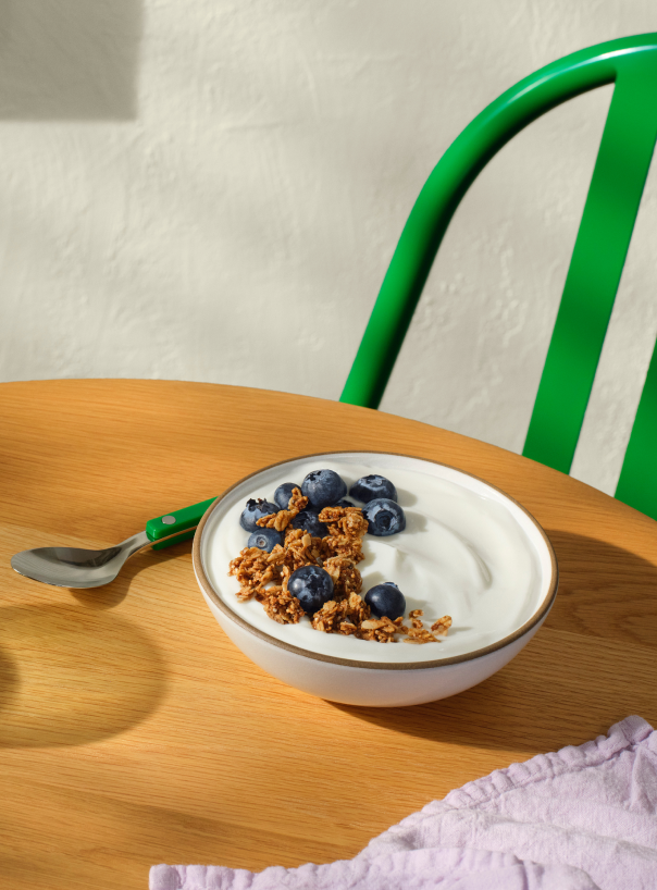 Yogurt with blueberries and granola on table