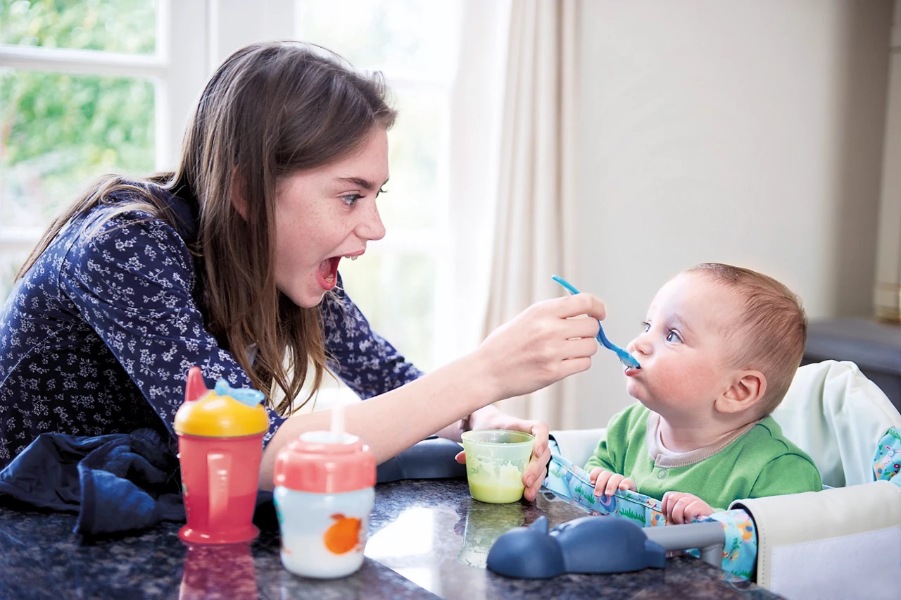 mum feed baby on table