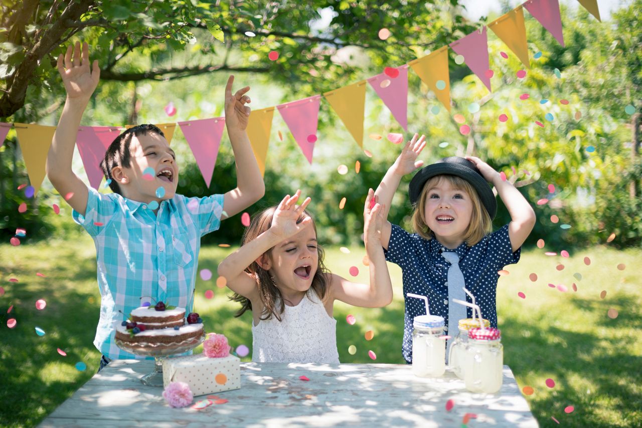 Little children celebrating birthday party. Confetti in the air.