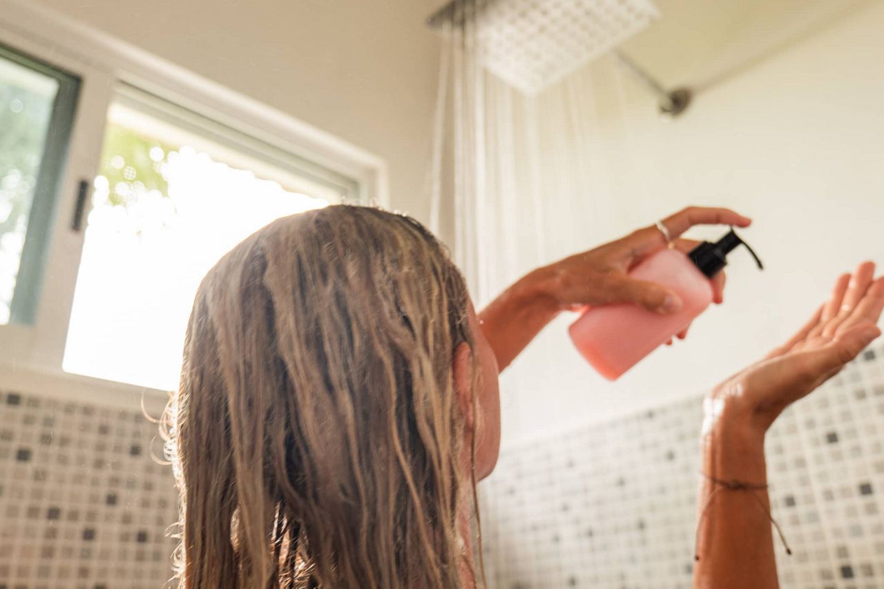 Frau duscht und wäscht sich die Haare