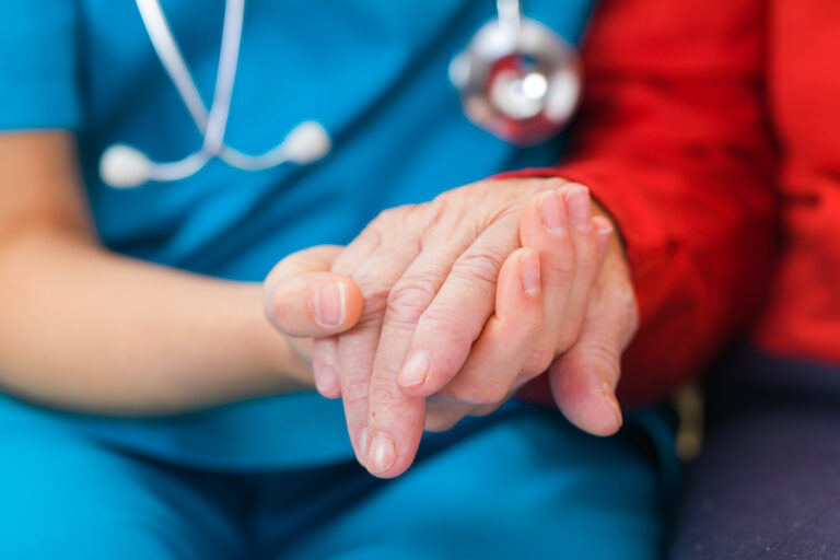 Doctor holding hands with elderly person