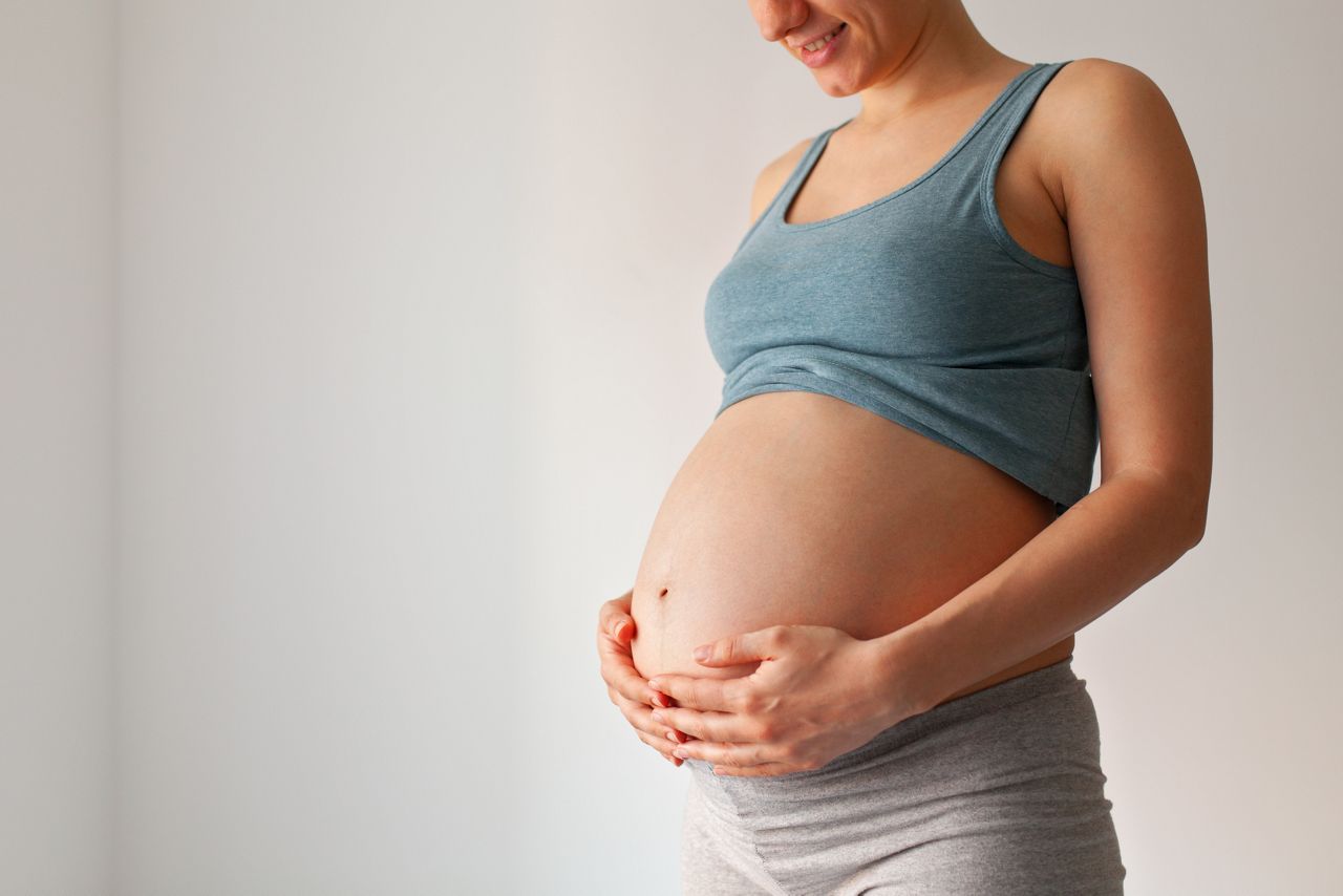 Pregnant woman standing against copyspace