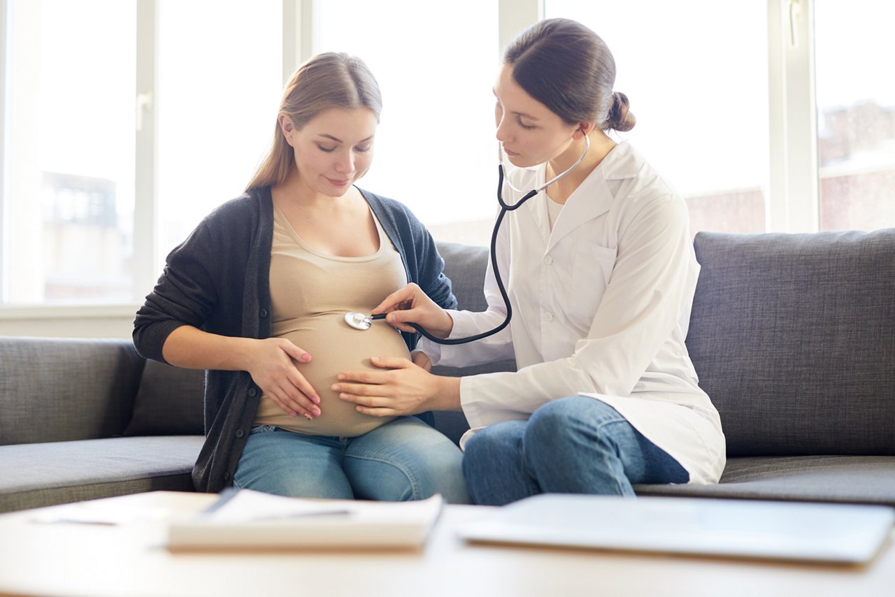 Portrait of female obstetrician listening to baby heartbeat putting sthetoscope to pregnant belly, copy space getty images 1147277750