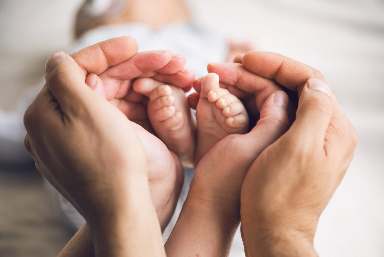 Little baby feet in parents hands getty images 1056431092